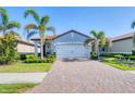 Charming single-story home with a red tile roof, lush landscaping, and a brick driveway at 197 Villoresi Blvd, Nokomis, FL 34275