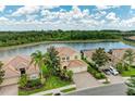 Beautiful aerial view of home on the water with manicured landscaping and a brick driveway at 235 River Enclave Ct, Bradenton, FL 34212