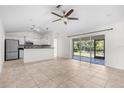 Open-concept living room featuring tile flooring, a ceiling fan, and sliding glass doors to the patio at 2575 Johannesberg Rd, North Port, FL 34288
