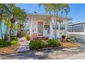 Charming coastal home featuring a coral door, lush landscaping, and a cozy, inviting entryway at 2601 Gulf N Dr # 733, Bradenton Beach, FL 34217