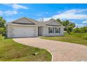 Charming single-story home with brick driveway, shutters, and attached two car garage at 27519 Pasto Dr, Punta Gorda, FL 33983