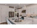 Modern kitchen featuring white cabinetry, stainless steel appliances, and a spacious island with bar seating at 3221 Vicenza Ct, Bradenton, FL 34211