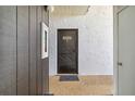 A condo entrance featuring textured walls, unit number, and a welcome mat inviting guests inside at 3269 Beneva Rd # 103, Sarasota, FL 34232