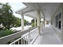 Long covered outdoor walkway with white columns offering shade and showcasing the building's architecture at 3803 54Th W Dr # 201, Bradenton, FL 34210