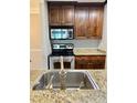 This home showcases a stainless steel sink, granite counters, and well-maintained appliances and dark cabinetry at 4037 Crockers Lake Blvd # 14, Sarasota, FL 34238