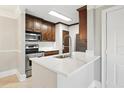 Stylish kitchen with stainless steel appliances, white countertop, and dark wood cabinets at 4037 Crockers Lake Blvd # 14, Sarasota, FL 34238