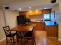 Eat-in kitchen with a table, wooden cabinets, and black appliances at 4607 W North B St # 105, Tampa, FL 33609