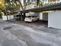 Assigned covered parking area with cars parked under the metal awning at 4607 W North B St # 105, Tampa, FL 33609