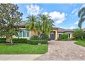 Beautiful home with paver driveway, lush lawn, manicured landscaping, and striking blue double-door entry at 4818 88Th E St, Bradenton, FL 34211
