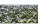 An aerial view of a neighborhood featuring lush trees and city skyline in the background at 515 N Osprey Ave, Sarasota, FL 34236