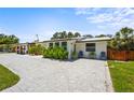 Inviting single-story home with a stylish paver driveway and lush tropical landscaping with decorative outdoor seating at 515 N Osprey Ave, Sarasota, FL 34236