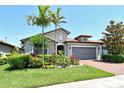 Inviting one-story home with tile roof, brick driveway, and lush tropical landscaping offering wonderful curb appeal at 5968 Snowy Egret Dr, Sarasota, FL 34238