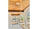 Keystone arched entry with wood ceiling and wrought iron entry gate beyond at 6524 Senegal Palm Way, Apollo Beach, FL 33572