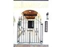Wrought iron entry gate with keystone arch, overhead wood ceiling, and address plaque at 6524 Senegal Palm Way, Apollo Beach, FL 33572