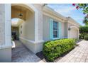 Home exterior showcasing an arched entryway, stucco walls, and a brick-paved walkway at 7164 Rue De Palisades # 5, Sarasota, FL 34238