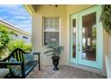 Inviting front porch with a bench, potted plant, and a glass-paneled front door at 7164 Rue De Palisades # 5, Sarasota, FL 34238
