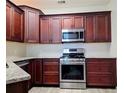 Modern kitchen with stainless steel oven, granite countertops, and dark wood cabinets, adding a luxurious feel at 834 Springwood Cir, Bradenton, FL 34212