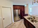 Kitchen showcasing stainless steel refrigerator, granite countertops, sink, and matching dark wood cabinets at 834 Springwood Cir, Bradenton, FL 34212