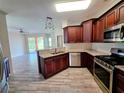 Spacious kitchen features stainless steel appliances, granite countertops and leads to a brightly lit living area at 834 Springwood Cir, Bradenton, FL 34212