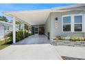 Spacious carport attached to a charming single-story home with a light-blue exterior and landscaped flower beds at 842 Jolanda Cir, Venice, FL 34285
