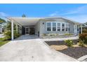 Charming single-story home with a light-blue exterior, landscaped flower beds, and a spacious carport at 842 Jolanda Cir, Venice, FL 34285