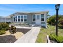 Charming single-story home with a light-blue exterior, landscaped flower beds, and a well-lit walkway at 842 Jolanda Cir, Venice, FL 34285