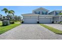 Two-story townhome with a two-car garage, paved driveway, green grass, and an American flag at 1017 Tidewater Shores Loop # 1017, Bradenton, FL 34208