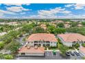 Sprawling aerial view of condo community with lush trees and landscaping and plenty of parking at 10202 L Pavia Blvd # 10202, Venice, FL 34292