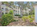 Attractive exterior view surrounded by lush landscaping and mature trees at 1170 Bird Bay Way # 206, Venice, FL 34285