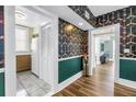 Hallway featuring unique wallpaper, hardwood floors, and access to the kitchen and living areas at 1221 N Palm Ave # 303, Sarasota, FL 34236