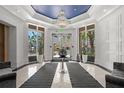 Elegant lobby with a large chandelier, black and white tiled floor, potted plants, and seating at 1350 Main St # 1703, Sarasota, FL 34236