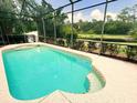 Screened-in pool with clear water, lovely deck, and views of the lush greenery and pond at 13809 18Th E Pl, Bradenton, FL 34212