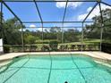 Sparkling pool in screened enclosure with scenic views of the pond and surrounding greenery at 13809 18Th E Pl, Bradenton, FL 34212