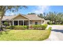 Well-maintained home with a screened-in porch and lush landscaping showcasing curb appeal at 1651 Red Oak Ln, Port Charlotte, FL 33948