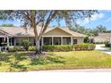 Charming home featuring a screened-in porch, mature tree, and meticulously maintained lawn at 1651 Red Oak Ln, Port Charlotte, FL 33948