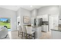 Bright kitchen features a breakfast bar, stainless steel appliances and scenic backyard view at 17065 Kellog Ave, Port Charlotte, FL 33954