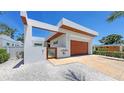 Sleek modern home showcasing its clean lines, stylish architecture, and inviting wood garage door at 2135 Hyde Park St, Sarasota, FL 34239