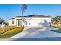 Beautiful home with a three-car garage and a concrete driveway under a bright sky at 2258 Margaret Ln, North Port, FL 34286