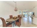 An inviting dining area with stylish woven chairs, an elegant light fixture, and serene water views at 24065 Canterwood Way, Venice, FL 34293