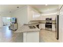 A bright kitchen featuring granite countertops, stainless steel appliances, and ample cabinet space at 24065 Canterwood Way, Venice, FL 34293