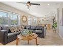 Bright living room featuring a large sectional, ceiling fan, round mirror and an open floorplan at 2908 Gulf Dr, Holmes Beach, FL 34217