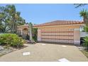 Spacious two-car garage with a decorative door and wide driveway at 321 Sorrento Dr, Osprey, FL 34229