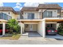 Townhome carport with white columns, door, and balcony with dark railings, providing covered parking and outdoor space at 3212 Ramblewood N Dr # 3212, Sarasota, FL 34237
