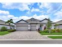 Charming single-story home with brick-paved driveway, well-manicured landscaping and attached three car garage at 3707 Wild Blossom Pl, Parrish, FL 34219