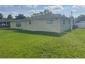 Well-maintained backyard with green grass and home's exterior, showcasing ample outdoor space at 48 Dade Ave, Sarasota, FL 34232
