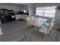 Bright dining area featuring a table with white chairs and a kitchen view at 5118 Oakland Hills Ave, Sarasota, FL 34234
