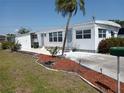 Charming single-story home featuring a palm tree, green lawn, and landscaped garden beds at 5118 Oakland Hills Ave, Sarasota, FL 34234