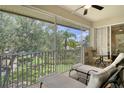 Relaxing screened balcony features sun loungers, fan, and a beautiful view of the outdoors at 6552 Moorings Point Cir # 201, Lakewood Ranch, FL 34202