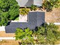 An aerial view of the home's roof, backyard patio area with furniture, and surrounding mature trees at 777 51St N Ave, St Petersburg, FL 33703