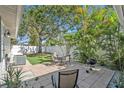 Backyard patio boasts ample seating and a grill, set amongst tropical landscaping and green lawn at 777 51St N Ave, St Petersburg, FL 33703
